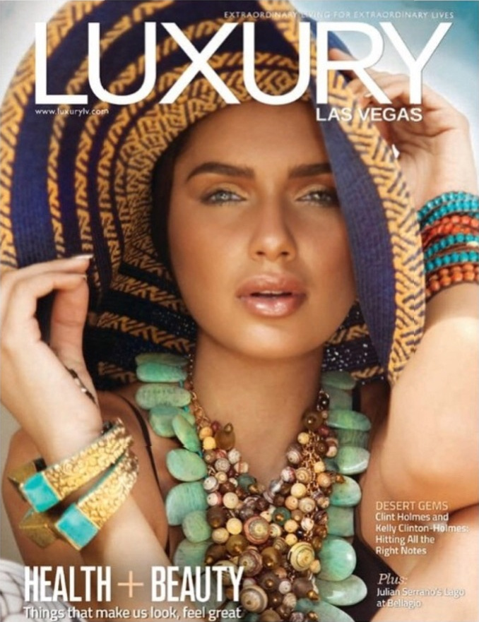 Luxury Las Vegas magazine cover: close-up of Jamillette Gaxiola under a wide blue and orange woven hat, wearing a chunky green stone and shell necklace, gold cuffs and beaded bracelets.